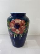 A Moorcroft vase, floral decoration with blue ground, (h 16cm)