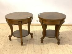 A pair of French Empire style walnut lamp tables, the circualr tops raised on shaped and square