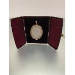 An Edwardian oval yellow metal miniature portrait frame complete with original burgundy leather