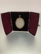 An Edwardian oval yellow metal miniature portrait frame complete with original burgundy leather