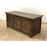 A large 18th century oak three panel coffer, two plank hinged top over lunette carved frieze and