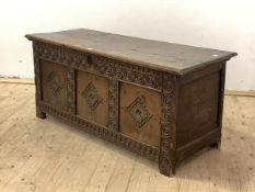 A large 18th century oak three panel coffer, two plank hinged top over lunette carved frieze and