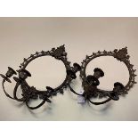 A pair of 19thc style cast iron circular framed wall mirrors with mask and c scroll surmounts fitted