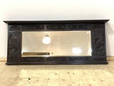 A 1930's carved oak over mantel mirror with rectangular bevelled plate, 132cm x 56cm