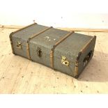 A travelling trunk, first half of the 20th century, wooden bound and with leather carry handle to
