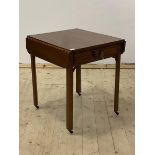 An Edwardian mahogany drop leaf table, with drawer, raised on square section supports terminating in