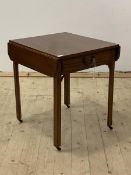 An Edwardian mahogany drop leaf table, with drawer, raised on square section supports terminating in