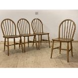 Ercol, A set of four mid century hoop and spindle back dining chairs with saddle seats, raised on