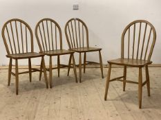 Ercol, A set of four mid century hoop and spindle back dining chairs with saddle seats, raised on