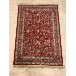 A Persian design silk pile rug, the red field with interlaced trailing foliate and bordered, 175cm x