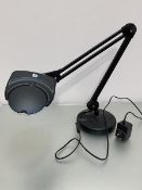 A daylight anglepoise style natural lamp with magnifying lens on adjustable arm and circular