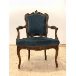 A late 19th century French walnut framed fauteuil, the floral carved crest rail over upholstered