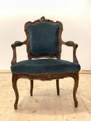 A late 19th century French walnut framed fauteuil, the floral carved crest rail over upholstered