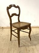 A late 19th century walnut bedroom chair, with rail back, cane seat, raised on cabriole front