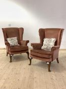Parker Knoll, a pair of upholstered wingback chairs, raised on walnut cabriole front supports,