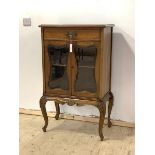 An Edwardian walnut side cabinet, with drawer over two bevel glazed doors, raised on cabriole