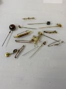 A collection of yellow metal and gold stick pins, and a dove with flower brooch, (a lot)