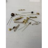 A collection of yellow metal and gold stick pins, and a dove with flower brooch, (a lot)