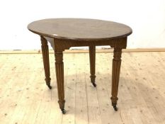 A Scottish 19th century oak library table, the oval top raised on turned reeded supports terminating