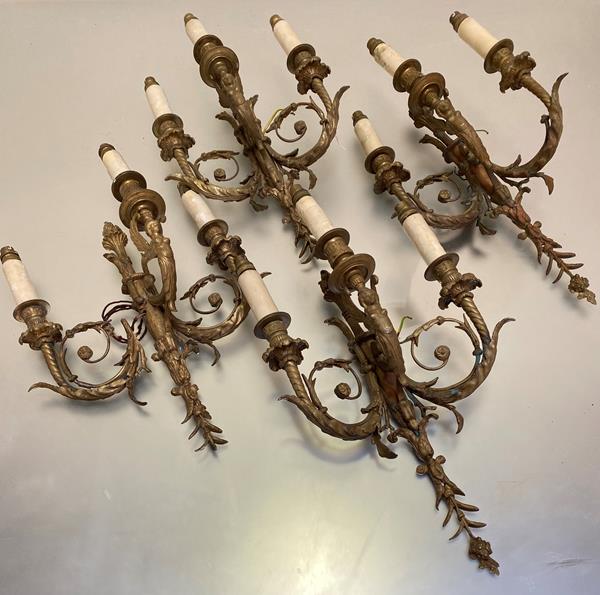 A set of four late 19thc cast brass three branch wall appliques in the Regency style with winged