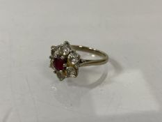 An 18ct gold cluster ring, London, with six diamonds surrounding ruby, size L