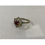 An 18ct gold cluster ring, London, with six diamonds surrounding ruby, size L