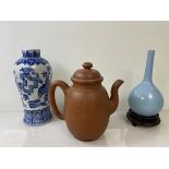 A Chinese unglazed teapot with character marks inscribed to to body and seal mark impressed to base,