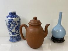 A Chinese unglazed teapot with character marks inscribed to to body and seal mark impressed to base,