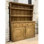 A 19th century pine dresser, with two height plate rack over two drawers and two cupboards,