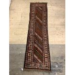 A hand knotted Persian runner rug with running dog border 305cm x 81cm