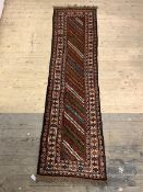 A hand knotted Persian runner rug with running dog border 305cm x 81cm