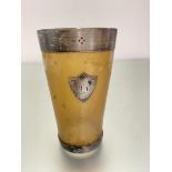 A George Adams silver mounted cow horn beaker with engraved crest and silver mount to glazed base,