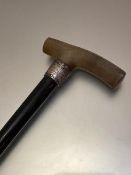 A late 19thc presentation horn handled ebony walking stick with white metal chased collar