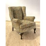 A Queen Anne style upholstered wingback chair with oak shell carved cabriole supports, H94cm, W66cm,
