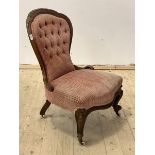 A Victorian mahogany button back slipper chair with floral carved crest rail, raised on scrolled