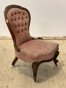 A Victorian mahogany button back slipper chair with floral carved crest rail, raised on scrolled