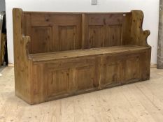 A 20th century reclaimed pine settle or hall seat, with shaped panel ends, four panel back over