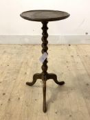 A late 19th century oak wine table, the dished circular top over spiral turned column and triple