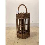 A two tier wicker basket, the top with handle, and four divisions under, possibly for bottles,
