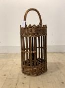 A two tier wicker basket, the top with handle, and four divisions under, possibly for bottles,