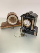 A Victorian black slate and onyx mounted arched top mantel clock with enamel dial showing roman