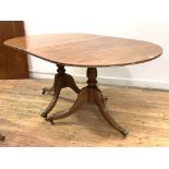 A Regency design mahogany twin pillar dining table, early 20th century, the reeded top with one leaf