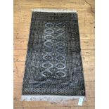 A Bokhara rug, hand knotted, with gul motif framed within multiple guard stripes to border, 94cm x