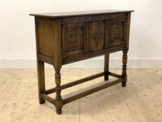 An 18th century style oak side cupboard, the top over frieze with simulated inlay, floral lozenge