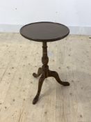 An early 20th century mahogany wine table, the circular top raised on triple splay supports,