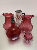 A pair of Edwardian cranberry glass water jugs, slight chips to rim, a pottery hot milk jug with