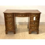 A Georgian style figured walnut serpentine knee hole desk, first half of the 20th century, with
