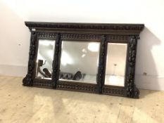 An early 20th century oak over mantel mirror, the egg and dart cornice over three sectional bevel