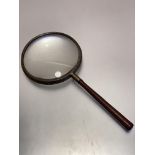 A large late 19thc brass mounted hand magnifying glass, with treen handle, (L 27cm x d 12cm)
