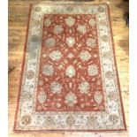A Zeigler style hand knotted rug, the faded red field with interlaced foliate and lotus head
